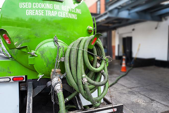 a grease trap being pumped by a sanitation technician in Auburndale